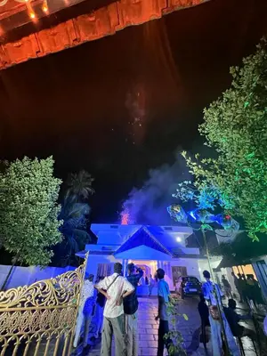 a group of people standing outside a house at night at Haveninn in Kallana