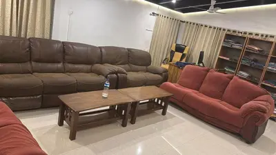 a living room with brown leather couches and a coffee table at Cityscape Residence and Homestay Tirupur in Tiruppūr