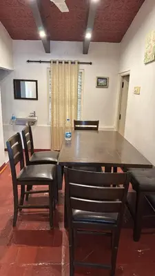 a large table with chairs and a bottle of water on it at Cityscape Residence and Homestay Tirupur in Tiruppūr