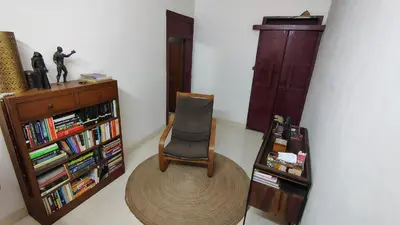 a room with a chair and a book shelf at Casa Areca in Cheruthuruthi