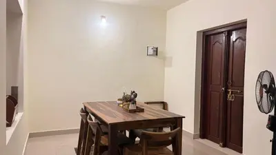 a dining room with a wooden table and chairs at Casa Areca in Cheruthuruthi