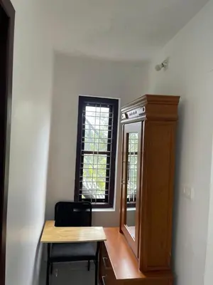 a room with a table and a cabinet and a window at Midnight Oasis Wayanad in Meenangadi