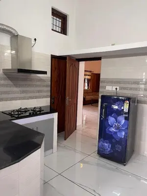 a kitchen with a refrigerator with a flower painted on it at Midnight Oasis Wayanad in Meenangadi