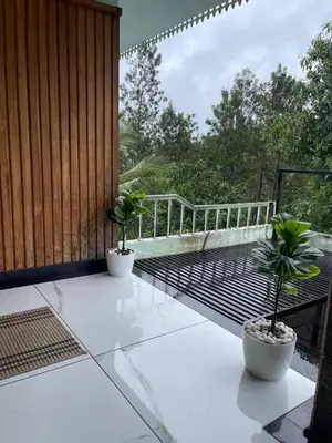 two potted plants on a balcony with a railing at Midnight Oasis Wayanad in Meenangadi