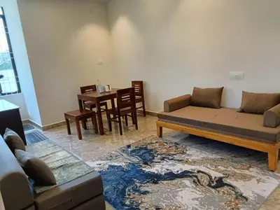a living room with a couch and a table at CLR Homestay & Villa in Kushālnagar