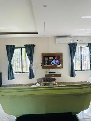 a living room with a green couch and a tv at CLR Homestay & Villa in Kushālnagar