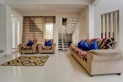 a living room with two couches and blue pillows at Palette Nirvana Signature Apartment by CheckIn, Coimbatore in Coimbatore