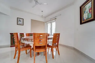 a dining room with a table and chairs at Palette Nirvana Signature Apartment by CheckIn, Coimbatore in Coimbatore