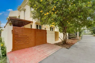 a house with a wooden gate in front of a driveway at Palette Nirvana Signature Apartment by CheckIn, Coimbatore in Coimbatore