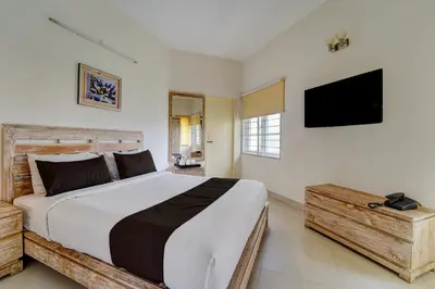 a bedroom with a large bed and a flat screen tv at Palette Nirvana Signature Apartment by CheckIn, Coimbatore in Coimbatore