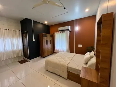 a bedroom with a bed and a ceiling fan at The Stellar By Stayzi in Nilambūr