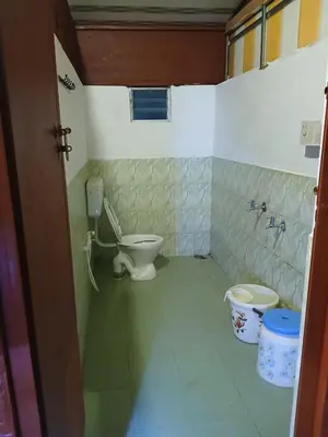 a bathroom with a toilet and two buckets in it at BeingWild Resort in Masinagudi