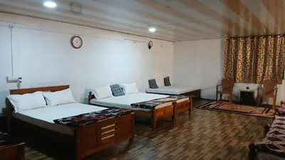 a room with two beds and a table in it at BeingWild Resort in Masinagudi