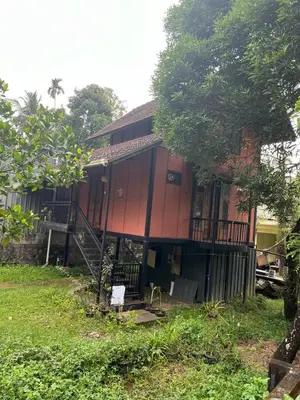 a house with a staircase in front of it at Apricot Cottage in Kozhikode