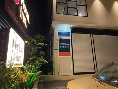 a building with a machine garage with a sign on the door at The Marina Deluxe Kozhikode - Premium Spacious AC Rooms in Kozhikode