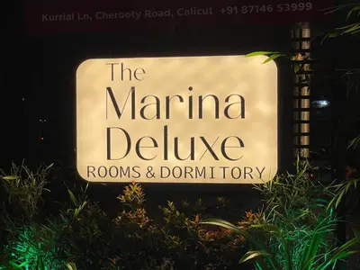 a sign for the marina deluxe rooms and bathroom at The Marina Deluxe Kozhikode - Premium Spacious AC Rooms in Kozhikode