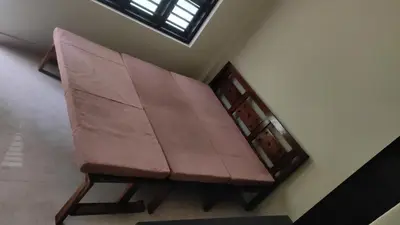 a bench sitting in the corner of a room at Green Valley stay in Pattāmbi