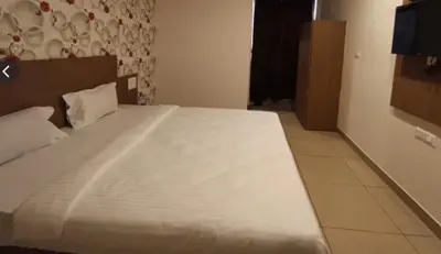 a bedroom with a large white bed in a room at Hotel Janani Mansion in Mysore
