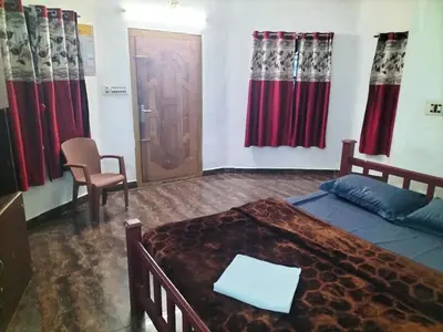 a bedroom with a bed and a door and curtains at Bhramaram resort in Kanthalloor