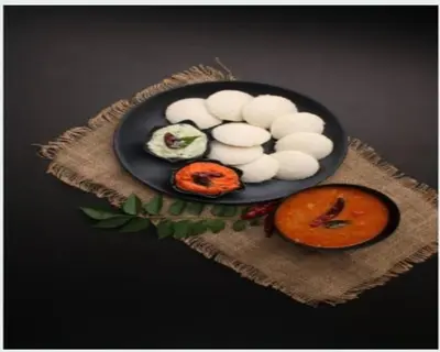 a plate of food with vegetables on a table at The Whistling Pine Woods in Varagampadi