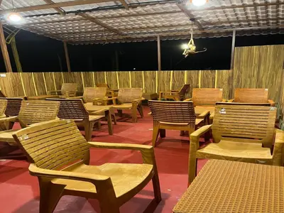 a row of chairs and tables in a restaurant at The Whistling Pine Woods in Varagampadi