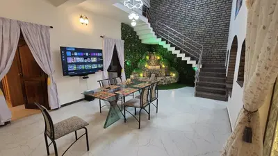 a dining room with a table and chairs and a fireplace at 5 BHK Luxurious & Spacious Villa in Mysuru in Mysore