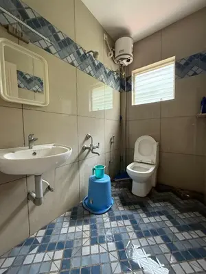a bathroom with a sink and a toilet at Murthi's Farm House in Coimbatore