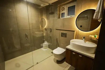a bathroom with a shower and a sink and a toilet at Townsquare Residency in Kommeri