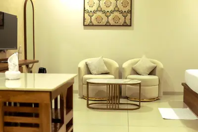 a living room with two chairs and a table at Townsquare Residency in Kommeri