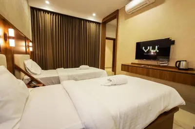a hotel room with two beds and a flat screen tv at Townsquare Residency in Kommeri