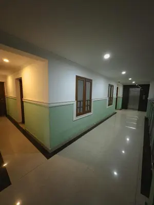 an empty room with green and white walls and windows at Sathya Inn Guruvayur in Trichūr