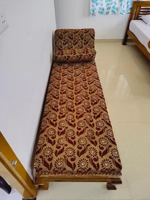 a bed sitting in the corner of a room at Maliyeckal Homes in Viripara