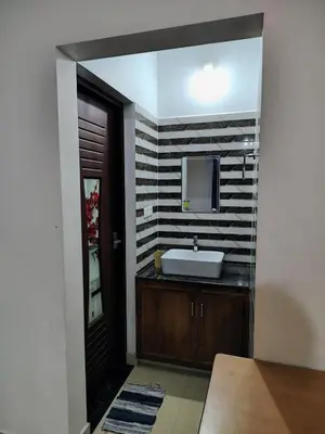 a bathroom with a sink and a mirror at Maliyeckal Homes in Viripara