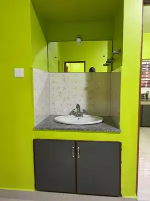a bathroom with a sink and a mirror at Essar Cottage in Ooty