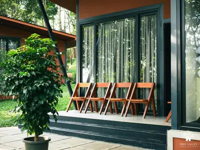 three chairs sitting on the front porch of a house at Tree Valley Resort Wayanad in Meppādi