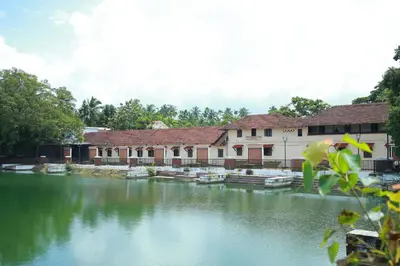 a river in front of a building with boats in it at Vinayaka Tourist Home in Kozhikode
