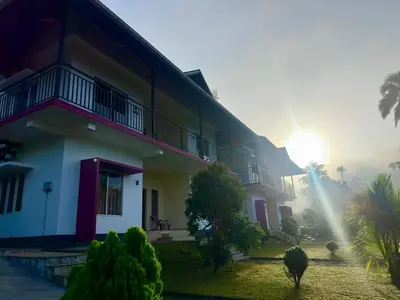 a house with the sun rising behind it at Karlad Lake Palace Waterfront Resort by stayRAa in Tariyod