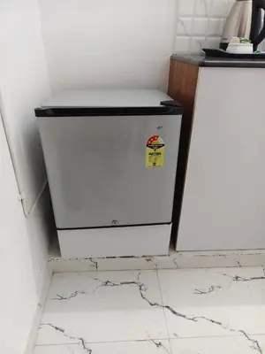 a white refrigerator in a kitchen with a counter at krishna paadham in Guruvāyūr