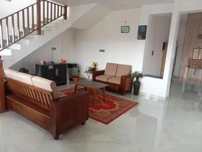a living room with a couch and a tv at Cherry Blossom in Kotagiri