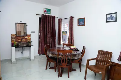 a dining room with a table and chairs at Cherry Blossom in Kotagiri