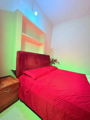 a bedroom with a red bed with a red blanket at sahara dua jungle farmstay in Wayanad