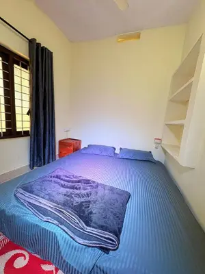 a bedroom with a bed with a purple blanket on it at sahara dua jungle farmstay in Wayanad