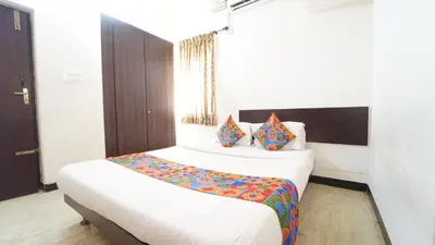 a bedroom with a large bed with colorful pillows at Aangal residency in Coimbatore