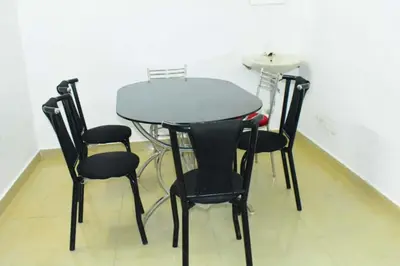 a table and four chairs in a room at Brindavan Lake Resort in Munnar