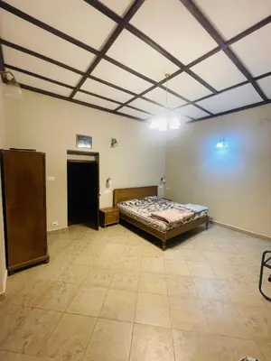a bedroom with a bed in the middle of a room at Balacalava Guest House in Coonoor