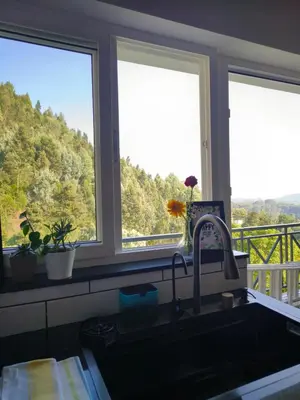 a kitchen with two windows and a sink with a view at Hope Horizon Luxury Villa By LexStays in Coonoor