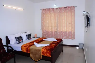 a bedroom with a bed with a window and a television at A L Residency in Ooty
