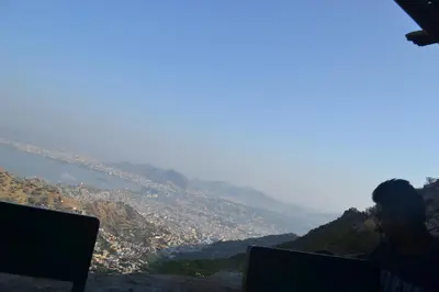 a man sitting on top of a mountain with a laptop at A L Residency in Ooty
