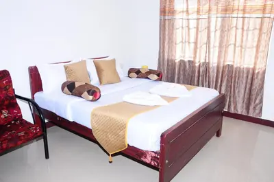 a bed in a room with a window and a chair at A L Residency in Ooty