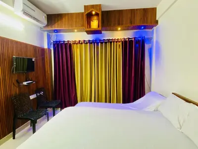 a bedroom with a bed and colorful curtains at Flat in Guruvayur- Sooryamadhavam Apartments- Family only in Guruvāyūr